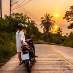 Voyageur en scooter sur une route tropicale en Thaïlande